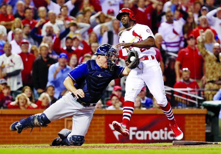 St. Louis Cardinals' Adolis Garcia (right) is tagged out at home by Milwaukee Brewers catcher Erik Kratz during the eighth inning of a baseball game in St. Louis on Wednesday.