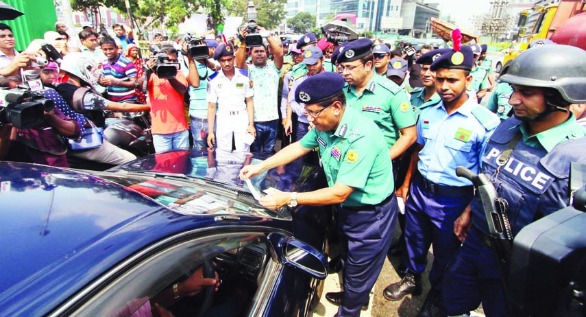 DMP Commissioner Md Asaduzzaman Mia distributing stickers with different slogans to create awareness on traffic system in the city yesterday. This picture was taken from Sonargaon Crossing.