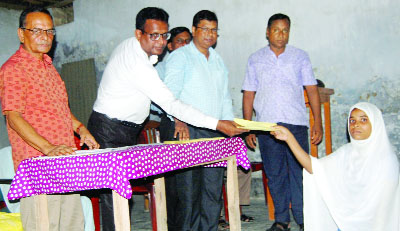 MANIKGANJ: Former senior teacher of Daulatpur PS Model High School Md Sajahan Ali distributing Dr M A Jaman Scholarship among the meritorious students at the school premises recently.