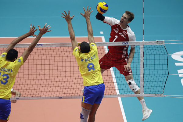 Poland's Artur Szalpuk hits the ball as Brazil's Mauricio Souza (left) and Brazil's Wallace De Souza (center) jump to block the ball during the Men's World Championships volleyball final match between Brazil and Poland, in Turin, Italy on Sunday.