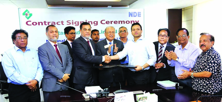 Md. Motaleb Hossain, DMD of Standard Bank Limited and Rezwan Mustafiz, Managing Director of National Development Engineers Limited, exchanging a contract signing document for construction of Corporate Head Office building of the Bank at its head office in