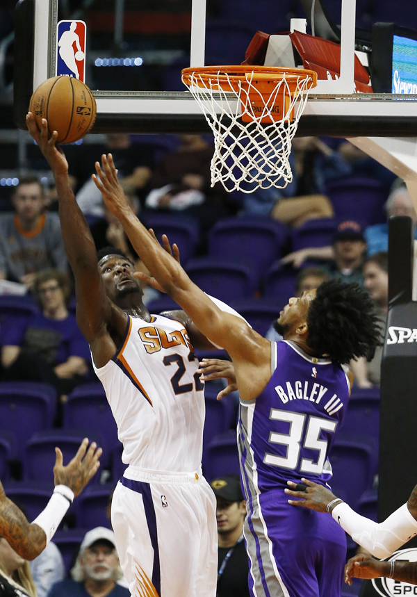 Phoenix Suns center Deandre Ayton (22) tries to get off a shot over Sacramento Kings forward Marvin Bagley III (35) during the first half of a pre-season NBA basketball game in Phoenix on Monday.