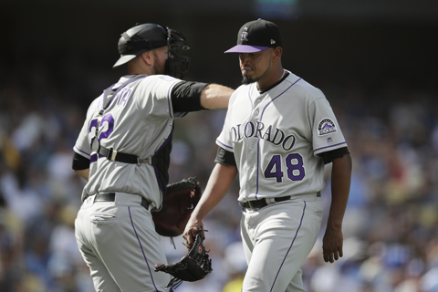 Colorado Rockies' Chris Iannetta (left) pats the back of starting pitcher German Marquez as Marquez leaves the mound after he was relieved during the fifth inning of a tiebreaker baseball game against the Los Angeles Dodgers in Los Angeles on Monday.