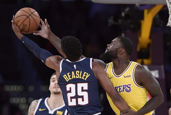 Denver Nuggets guard Malik Beasley (left) and Los Angeles Lakers guard Lance Stephenson reach for a rebound during the first half of an NBA basketball game in Los Angeles on Tuesday.