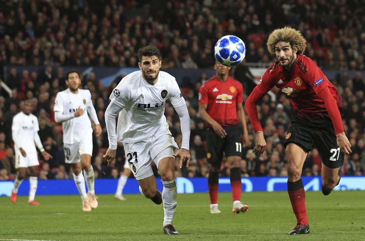 ManU midfielder Marouane Fellaini (right) runs for the ball with Valencia defender Cristiano Picciniduring the Champions League group H soccer match between Manchester United and Valencia at Old Trafford Stadium in Manchester, England, onTuesday.