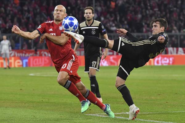 Ajax's Nicolas Tagliafico (right) and Bayern midfielder Arjen Robben (left) vie for the ball during a Group E Champions League soccer match between Bayern Munich and Ajax at the Allianz Arena in Munich, Germany on Tuesday.