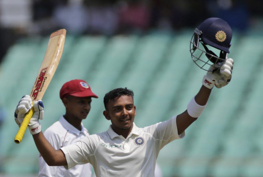 Indian cricketer Prithvi Shaw celebrates his century during the first day of the first cricket test match between India and West Indies, in Rajkot, India on Thursday