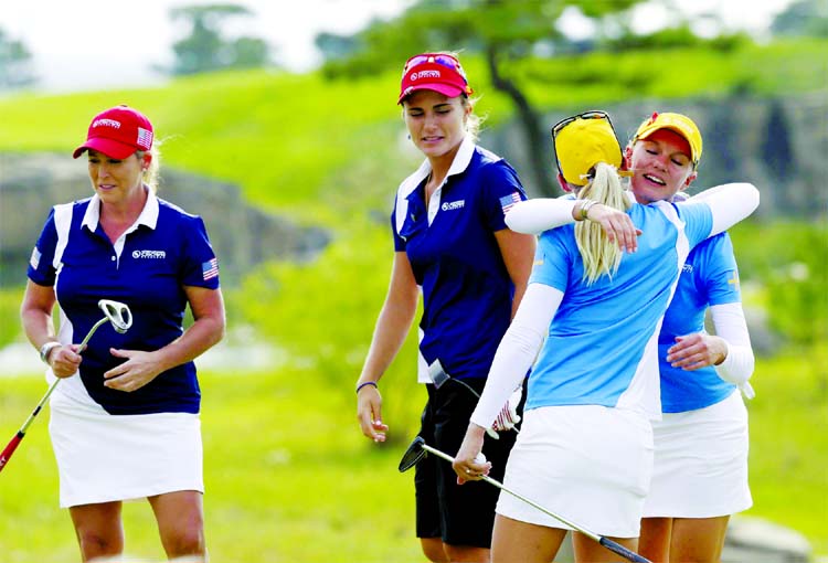 Sweden's Madelene Sagstrom (right) hugs with her teammate Pernilla Lindberg as the United States's Lexi Thompson and Cristie Kerr (left) leave on the 18nd hole after the first round of the LPGA's UL International Crown golf tournament at the Jack Nickl