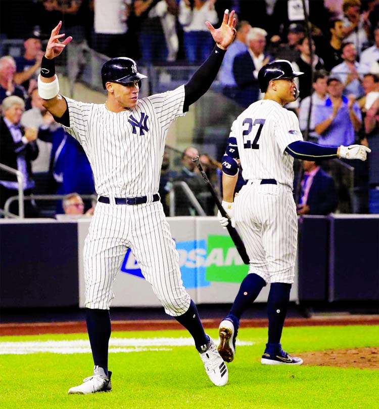 New York Yankees' Aaron Judge (left) reacts after scoring on a double by Aaron Hicks during the sixth inning of the American League wild-card playoff baseball game in New York on Wednesday.
