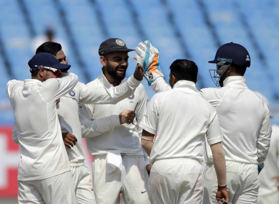 Indian cricketer Virat Kohli (center) celebrates with teammates after the dismissal of West Indies' Keemo Paul during the third day of the first cricket Test match between India and West Indies, in Rajkot, India on Saturday.