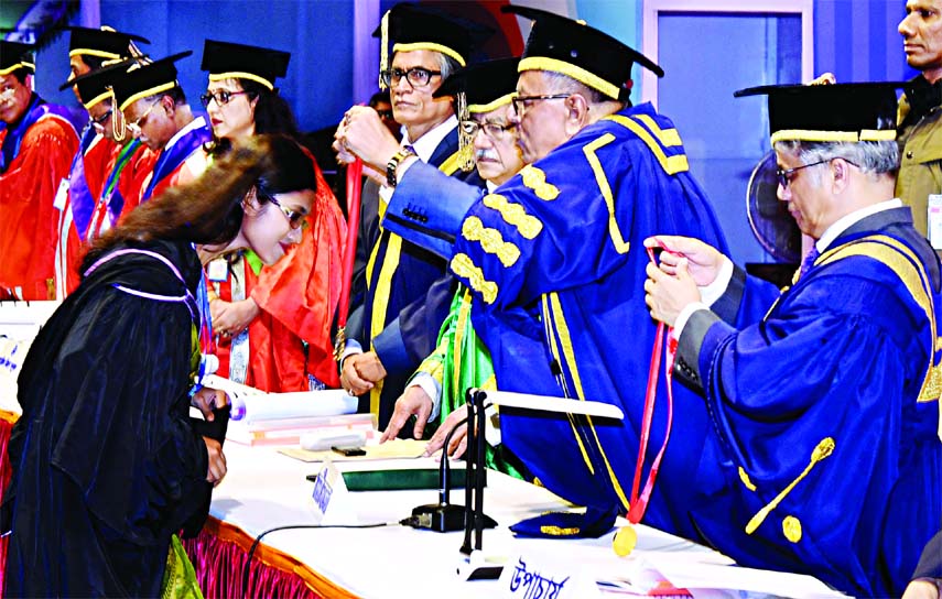 President Abdul Hamid handing over certificates and crests to DU graduates at the 51st convocation programme held at its central play ground on Saturday.