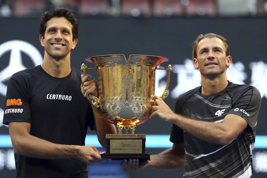 Marcelo Melo of Brazil (left) and Lukasz Kubot of Poland pose with the winner's trophy after beating Oliver Marach of Austria and Mate Pavic of Croatia in the men's doubles final in the China Open at the National Tennis Center in Beijing on Sunday.