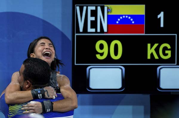 Katherin Oriana Echandia Zarate of Venezuela celebrates jubilantly with her coach after winning the Gold Medal with a successful lift of 90kg during the Group A round in the Weightlifting Women's 44kg at the Europa Pavilion during the Youth Olympic Summe
