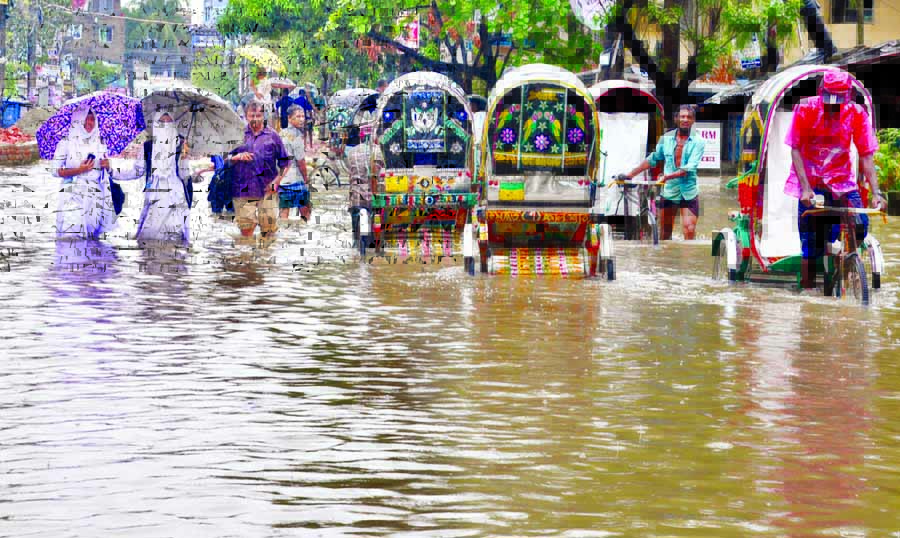 Low-lying areas of Chattogram went under rain and tidal waters, causing sufferings to city dwellers. Photo shows rickshawpullers struggling to wade through waist-deep waters on Tuesday.