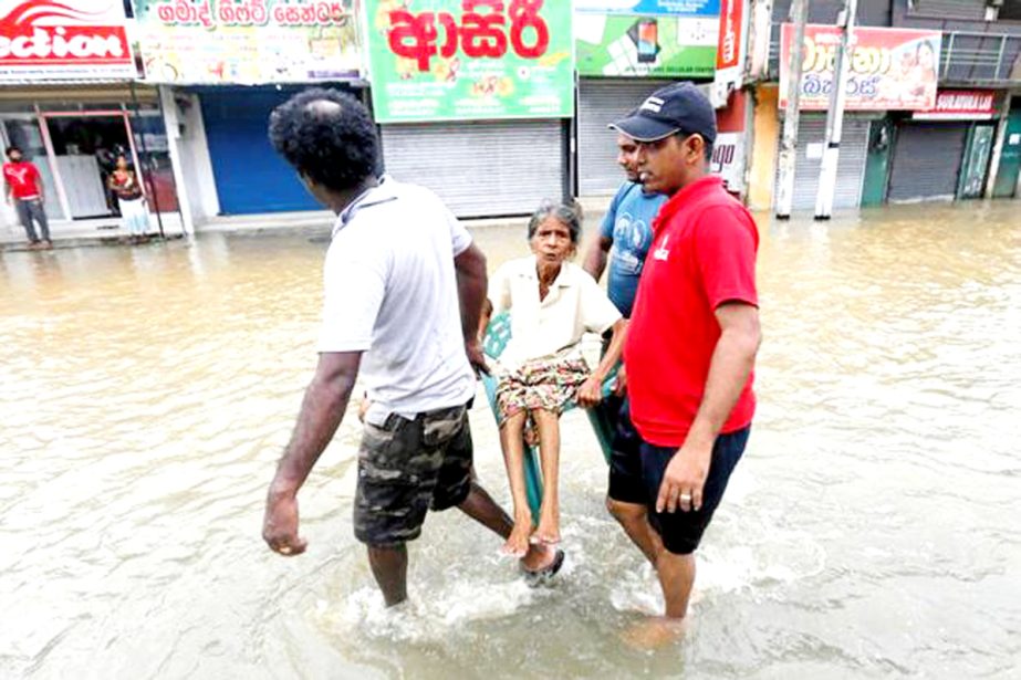 Villagers carry an elderly woman on a chair through a flooded road as they flee their homes in Biyagama, in Western province of Sri Lanka in search for safer areas.