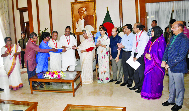 Prime Minister Sheikh Hasina handing over a cheque for Taka 20 crore to Sangbadik Kalyan Trust fund at Ganabhaban on Thursday.