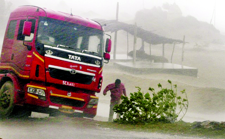 A truck driver comes out from his vehicle to take shelter near Gopalpur on the Bay of Bengal coast as cyclone Titli blowing up to 95 mph.