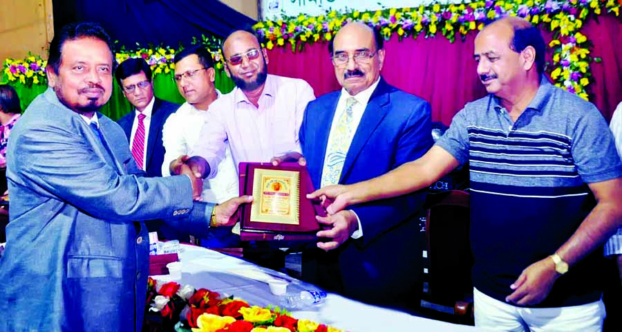 Awami League Advisory Council Member Advocate Yusuf Hossain Humayun handing over a crest to freedom fighter and Managing Director of Bulbul Securities Limited AS Shahadul Haque Bulbul at a reception organised by Simanta Cultural Foundation at the Central