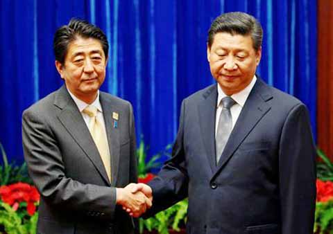 China's President Xi Jinping shakes hands with Japan's Prime Minister Shinzo Abe during their meeting at the Great Hall of the People, on the sidelines of the Asia Pacific Economic Cooperation (APEC) meetings, in Beijing.