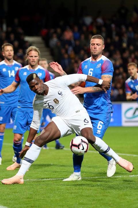 France's Paul Pogba (foreground) challenges for the ball with Iceland's Ragnar Sigurdsson, during a friendly soccer match between France and Iceland, in Guingamp, western France on Thursday.