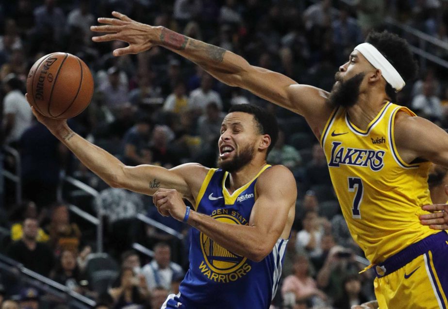 Golden State Warriors guard Stephen Curry shoots around Los Angeles Lakers center JaVale McGee during the second half of an NBA preseason basketball game in Las Vegas on Wednesday.