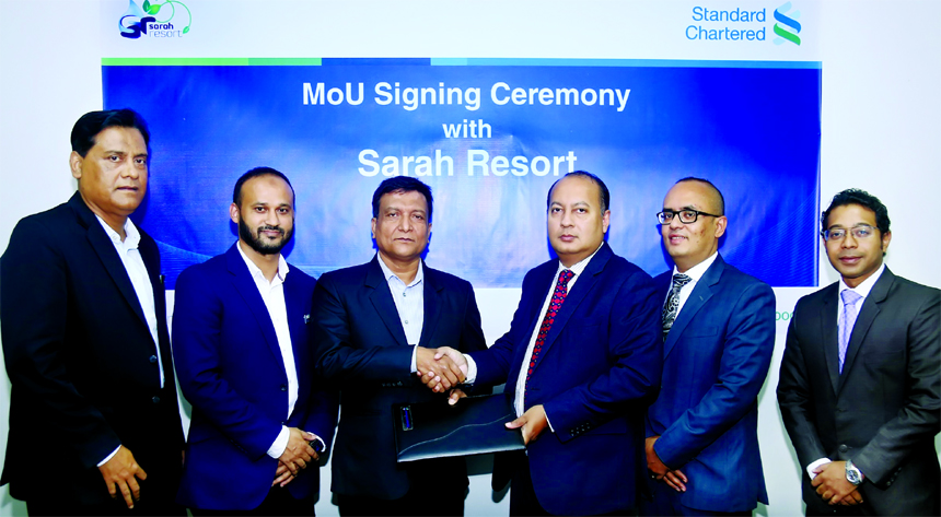 Mahiul Islam, Head of Retail Products and Segments of Standard Chartered Bank and Emdadul Haque, General Manager of Sarah Resort operated by Fortis Group, exchanging a MoU signing documents at the Bank's head office in the city recently. Under the deal,