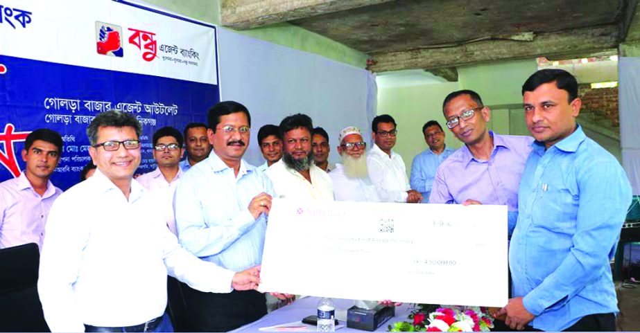 Md. Mehmood Husain, Managing Director of NRB Bank Limited, handing over a cheque of SME Loan at a inaugural ceremony of Agent Banking Outlet at Golora Bazar in Saturia of Manikgonj recently. Imran Ahmed, Chief Operating Officer, Abu Shayem, Head of SME an