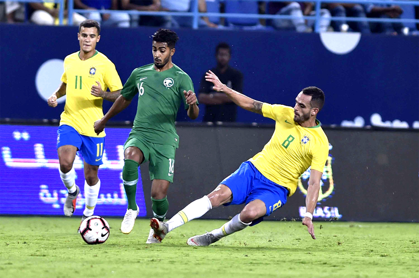 Saudi Arabia's Hussain Almoqahwi (center) is blocked by Brazil's Renato (right) during a friendly soccer match between Brazil and Saudi Arabia at King Saud University Stadium in Riyadh, Saudi Arabia on Friday.