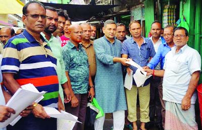 BETAGI(Barguna): Alhaj A B M Golum Kabir, Mayor, Betagi Pourashava distributing leaflet in front of Party Office during an election campaign for upcoming 11th Parliamentary Election on Saturday.