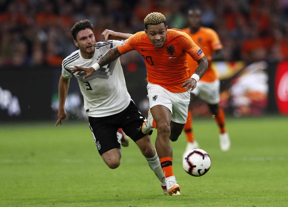 Netherland's Memphis Depay (right) runs faster with the ball than Germany's Jonas Hector (left) during the UEFA Nations League soccer match between The Netherlands and Germany at the Johan Cruyff Arena in Amsterdam on Saturday.