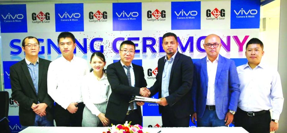 China-based mobile phone manufacturer company Vivo's CEO in Bangladesh Duke and mobile phone retailer Gadget and Gear's (G&G) Managing Director Nure Alam Shimu, exchanging an agreement signing document at Vivo's corporate office in the city recently. U