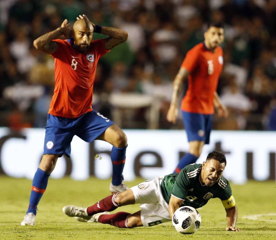 Chile's Arturo Vidal (left) fouls Mexico's Marco Fabian during a friendly soccer match between Mexico and Chile, in Queretaro, Mexico on Tuesday.