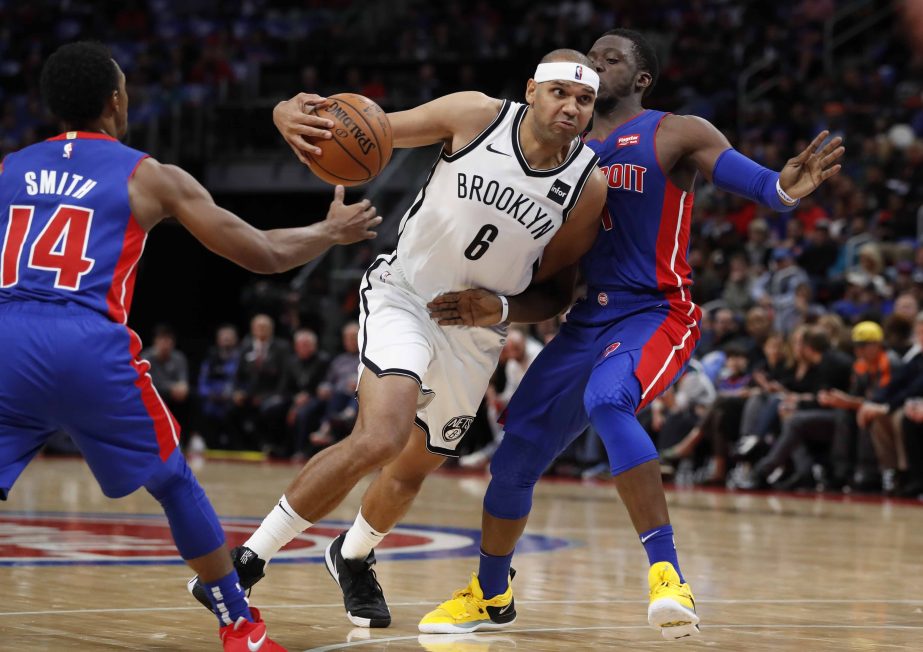 Brooklyn Nets forward Jared Dudley (6) drives between Detroit Pistons guards Ish Smith (14) and Reggie Jackson (1) during the first half of an NBA basketball game in Detroit on Wednesday.