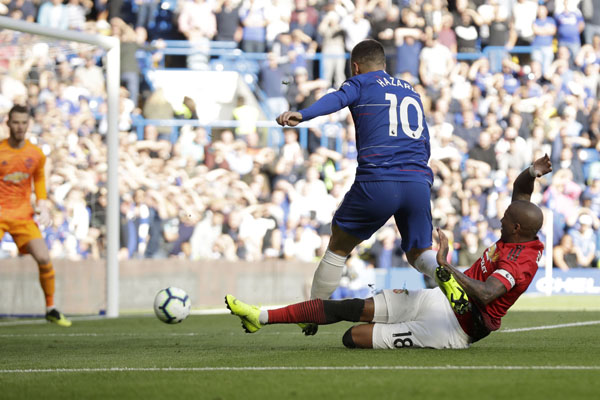 ManU midfielder Ashley Young tackles Chelsea's Eden Hazard during their English Premier League soccer match between Chelsea and Manchester United at Stamford Bridge stadium in London on Saturday.