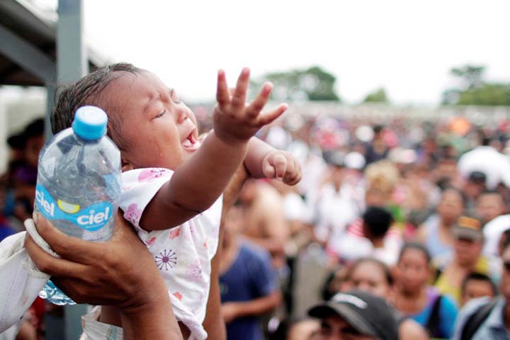 A baby cries as a caravan of migrants trying to reach the U.S., wait to apply for asylum in Mexico at a checkpoint in Ciudad Hidalgo, Mexico on Saturday.