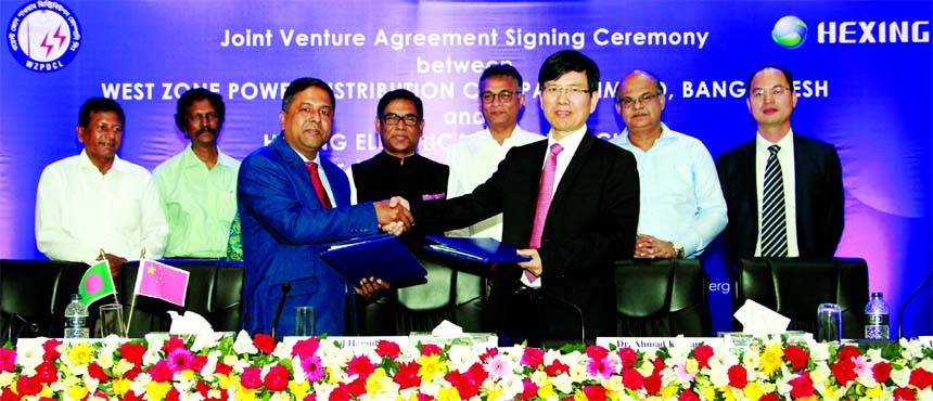Abdul Motaleb, Company Secretary of West Zone Power Distribution Company Limited (WZPDCL), Bangladesh and Zhou Liang zhang, Chairman of Hexing Electrical Company Limited, China, exchanging an agreement signing document for implementation of a joint ventur