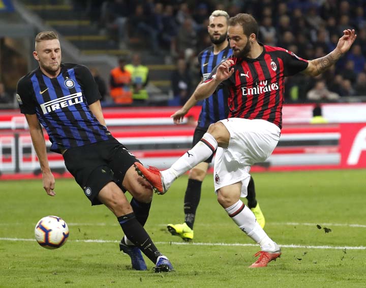 AC Milan's Gonzalo Higuain (right) and Inter Milan's Milan Skriniar vie fore the ball during the Serie A soccer match between Inter Milan and AC Milan at the San Siro Stadium, in Milan, Italy on Sunday.