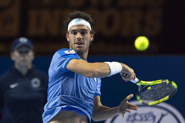 Italy's Marco Cecchinato returns a ball to Switzerland's Henri Laaksonen during their first round match at the Swiss Indoors tennis tournament at the St. Jakobshalle in Basel, Switzerland, on Monday.