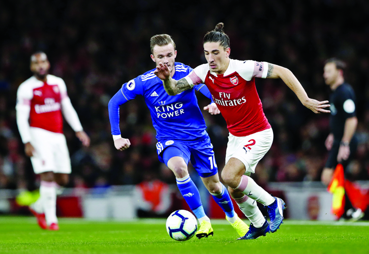 Leicester City's James Madison (left) vies for the ball with Arsenal's Hector Bellerin during the English Premier League soccer match between Arsenal and Leicester City at the Emirates stadium in London on Monday.