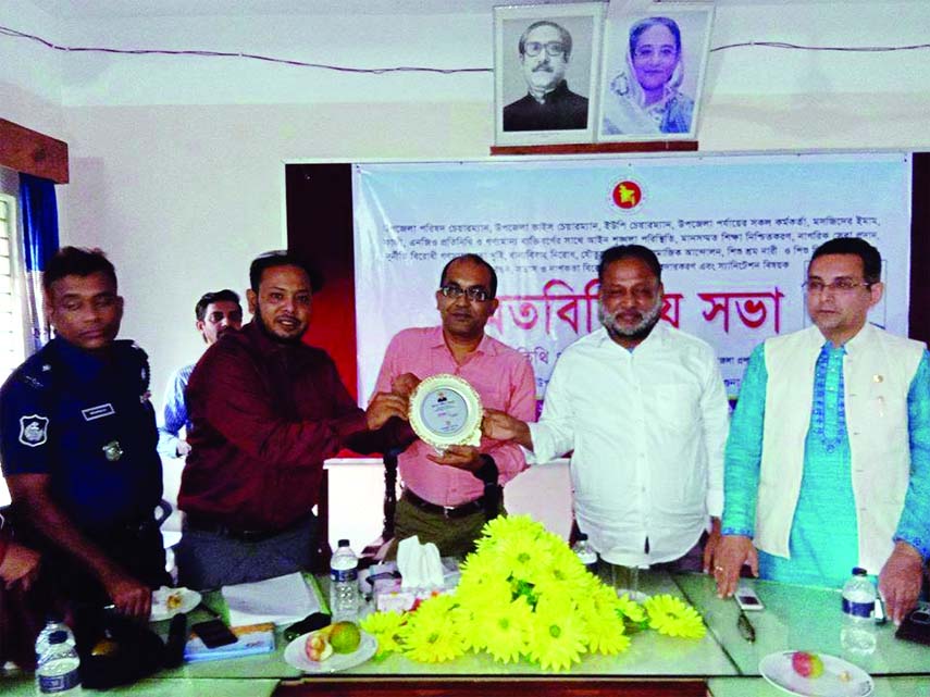 BETAGI (Barguna): Kabir Mahmud, DC, Barguna, receiving a crest given on behalf of Betagi Upazila Administration at view exchange meeting on drug abuses, dowry and early marriage prevention at UNO'S Conference Room recently.