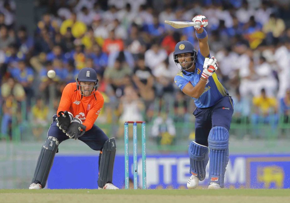 Sri Lanka's Dinesh Chandimal plays a shot as England's Jos Buttler watches during their fifth one-day international cricket match in Colombo, Sri Lanka on Tuesday.