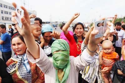 Uighur protesters pictured in 2009 wield the ID cards of detained relatives