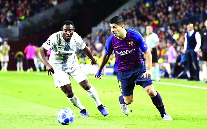 Barcelona forward Luis Suarez (right) controls the ball as Inter defender Kwadwo Asamoah defends during the Champions League, group B soccer match between Barcelona and Inter Milan, at the Nou Camp in Barcelona, Spain on Wednesday.