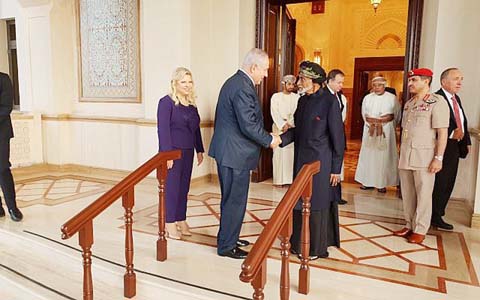 Prime Minister Benjamin Netanyahu (SL), acompanied by his wife Sara, is greeted by Sultan Qaboos bin Said in Oman on Friday.