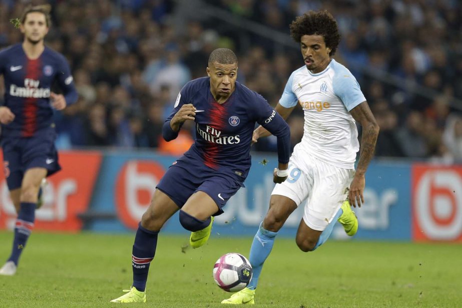 PSG's Kylian Mbappe (left) and Marseille's Gustavo Luiz challenge for the ball during the French League One soccer match between Paris-Saint-Germain and Marseille at the Velodrome Stadium in Marseille, France on Sunday.