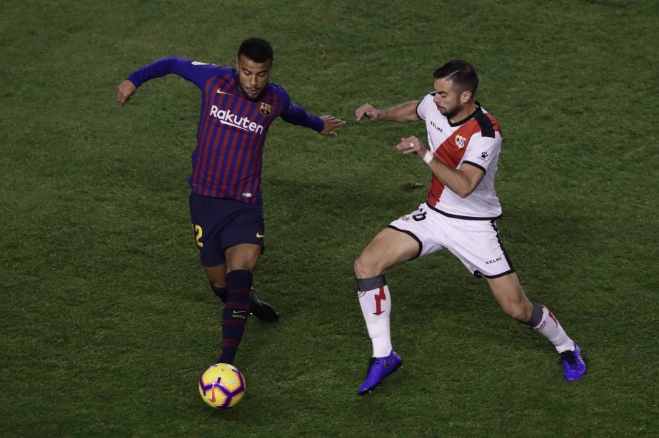 FC Barcelona's Rafinha (left) duels for the ball against Rayo Vallecano's Jordi Amat during the Spanish La Liga soccer match between Rayo Vallecano and FC Barcelona at the Vallecas stadium in Madrid, Spain on Saturday.