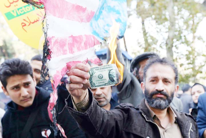 An Iranian protester burns a dollar banknote during a demonstration outside the former US embassy in the Iranian capital Tehran.