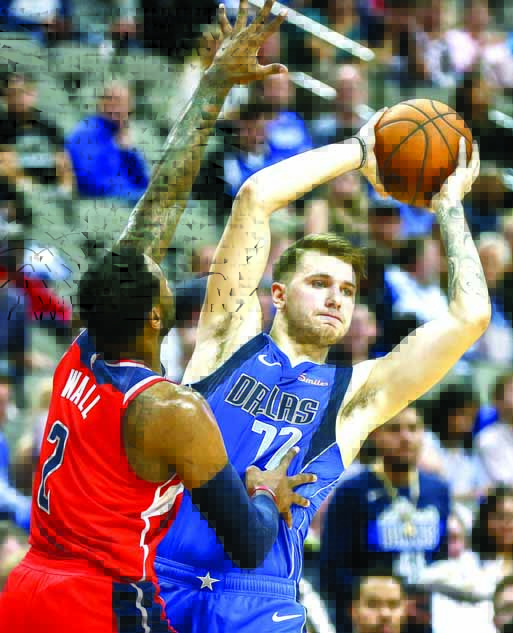Dallas Mavericks forward Luka Doncic (77) looks for an open teammate as Washington Wizards guard John Wall (2) defends during the second half of an NBA basketball game in Dallas on Tuesday.