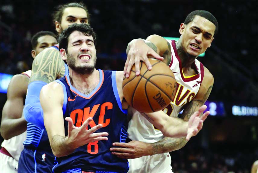 Oklahoma City Thunder's Alex Abrines (left) from Spain, and Cleveland Cavaliers' Jordan Clarkson compete for a loose ball during the first half of an NBA basketball game on Wednesday.