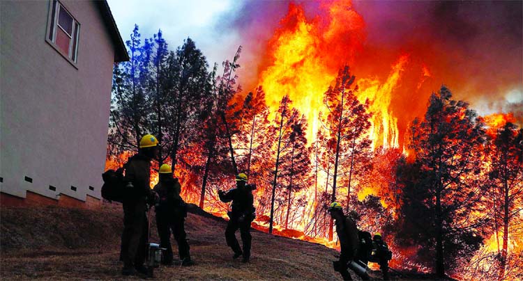 A group of US Forest Service firefighters monitor a back fire while battling to save homes at the Camp Fire in Paradise California in US.